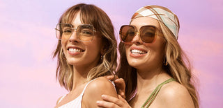 Two girls in beachwear on a pink and purple cloudy sky background looking into the distance - Feel Good Bronzing by Luna Bronze